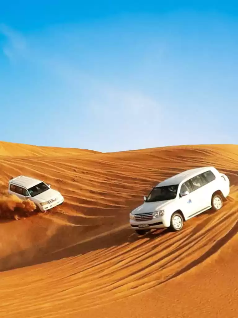Banner image of 2 white cars in dubai desert taking tourist for desert safari