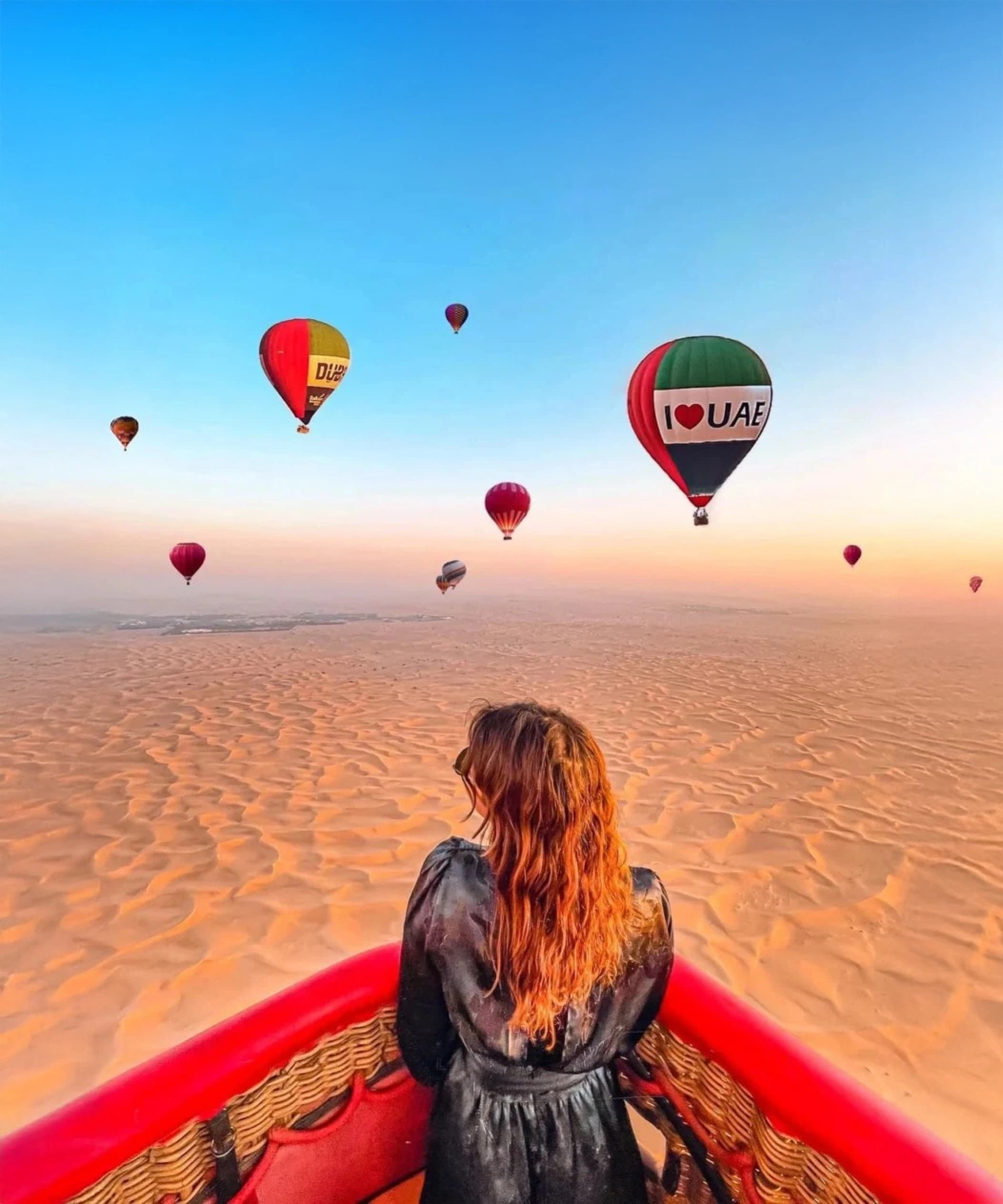 Hot air balloon over Dubai desert at sunrise
