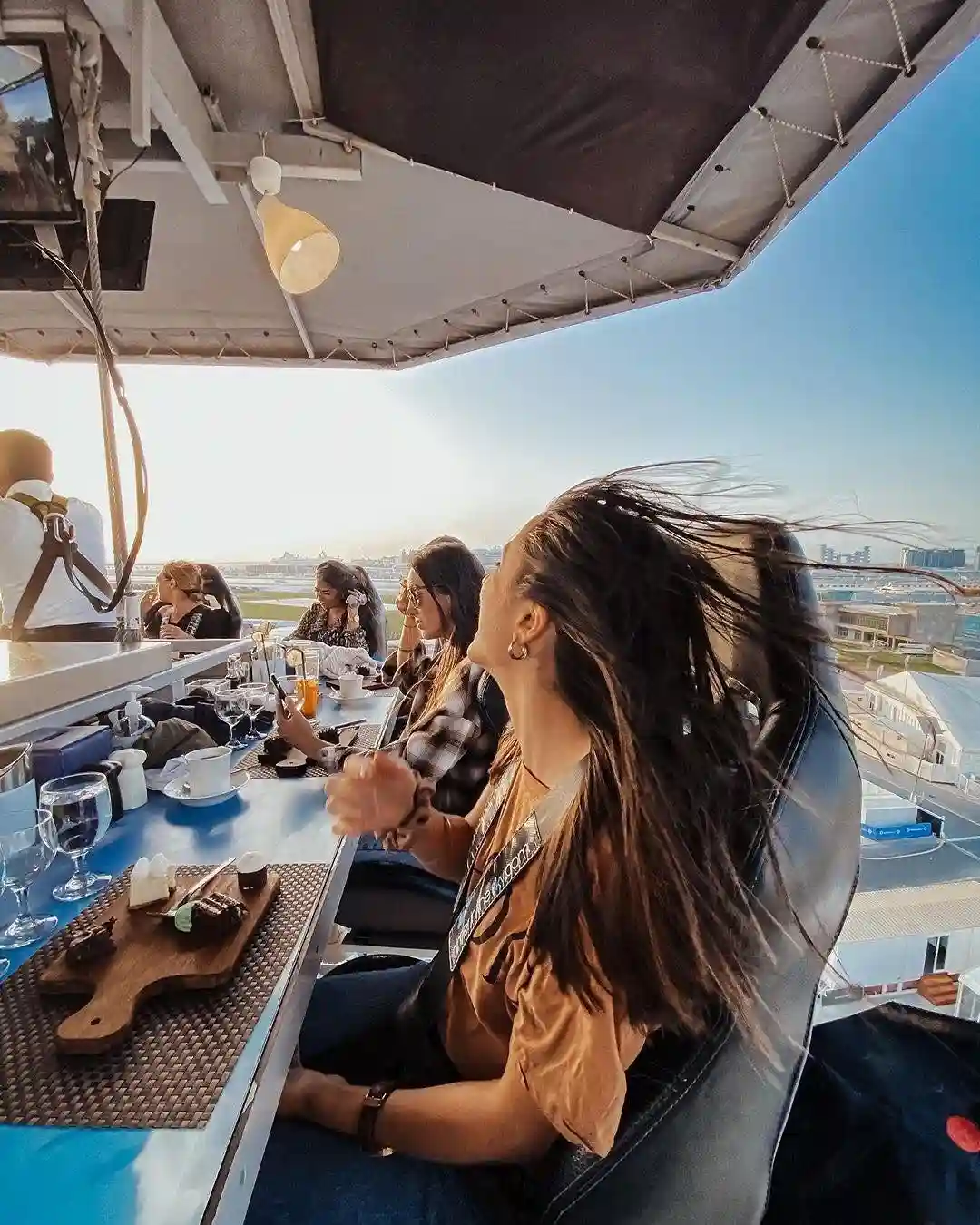 Dining table suspended in the air with guests enjoying dinner above Dubai skyline