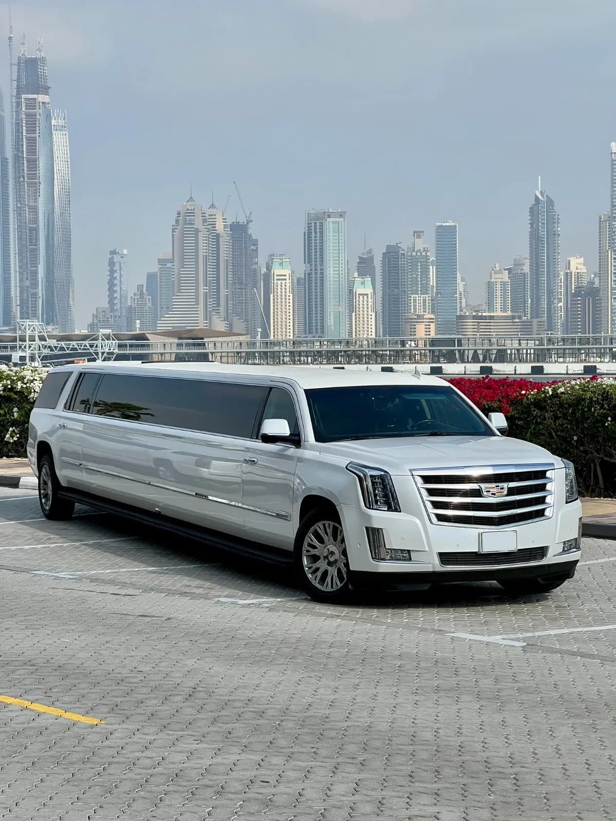 Luxury limousine driving through Dubai city with iconic landmarks in view