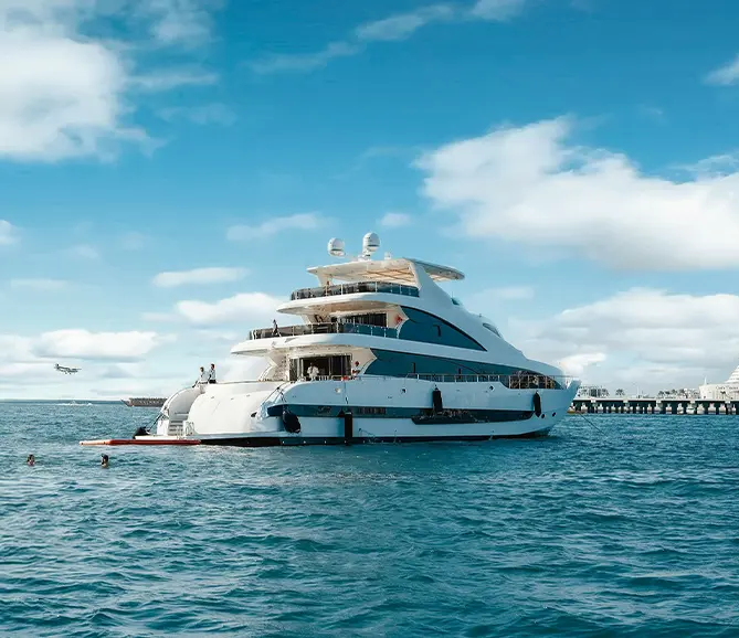 Luxury yacht cruising along Dubai coastline with skyline in the background