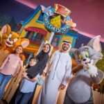 Image of Tom & Jerry & family in the warner bros. world posing for the photo
