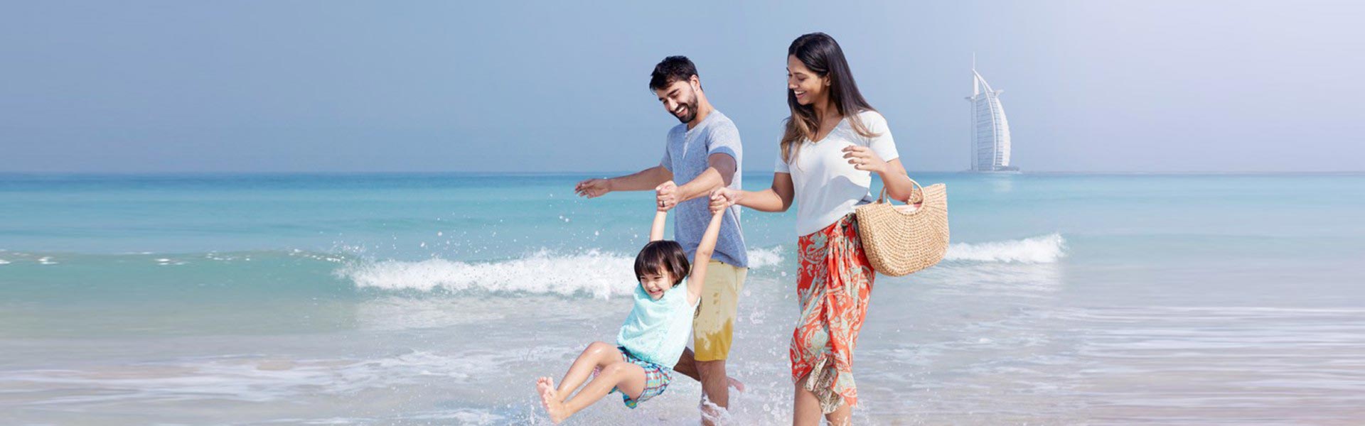 Banner image of family enjoying in UAE beach and 7 star hotel Burj Al Arab at distance
