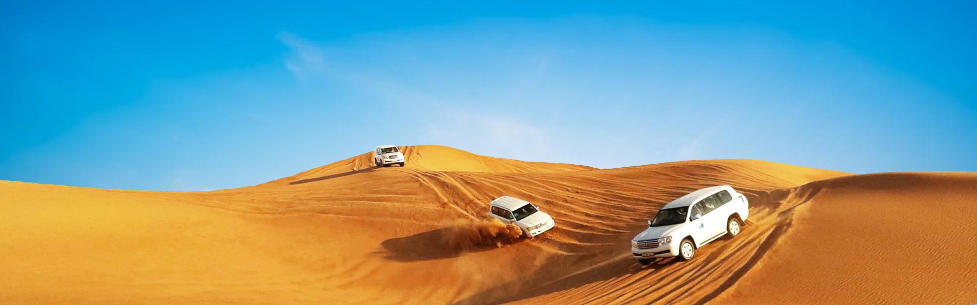 Banner image of 3 white cars in Dubai desert taking tourist for desert safari