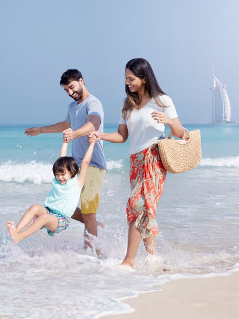 Imazhi i banderolës së familjes duke shijuar UAE plazh dhe hotel 7 yje Burj Al Arab në distancë
