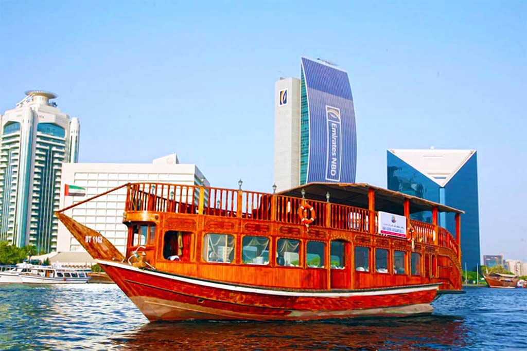 image of Dubai-creek-tour dhow cruise taking tourist to enjoy the sailing on UAE water
