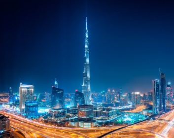 night view Image of Burj-Khalifa in between other building and heavy traffic highway