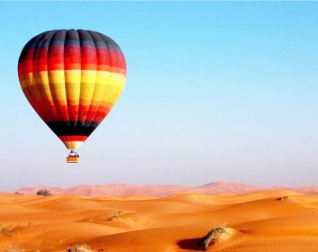 Tourists enjoying Hot-Air-Balloon in UAE with a beautiful view of Arabian desert